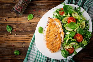 Grilled chicken breast and fresh vegetable salad - tomatoes, cuc